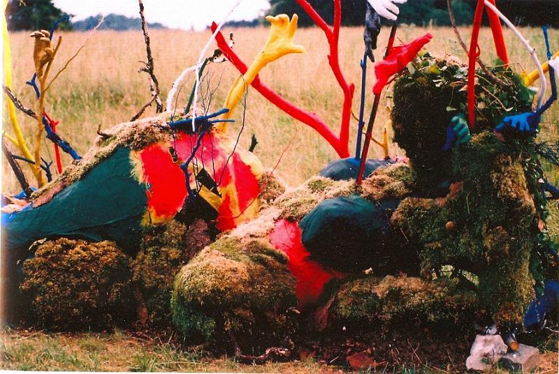 Urmutter Erde.jpg - 2007Pappmache, Holz, Naturmaterialien, Farbe. Bettina Casabianca verknüpft ihre Empfindungen zum Thema "Heimat" mit einer liegenden weiblichen Figur, die für sie Sinnbild der Erde als Mutter und erste Heimat des Menschen ist. "Heimat" ist für sie kein bestimmter ort, eher ein Netz zwischenmenschlicher Beziehungen, das in ihrer Skulptur durch die Hände symbolisiert wird. Deren Buntheit, die an tibetische Gebetsfahnen denken lasst, und ihre zum Himmel greifende Geste verweist auf die spirituelle Dimension dieser Arbeit. Gleichzeitig stehen die Hände für aktives Handeln, für Entwicklung und Vielfalt. Mit ihrer Farbigkeit und Lebendigkeit erinnern sie an Kinder, die sich von der Mutter lösen müssen, um auf eigenen Füßen zu stehen, sich in sich selbst zu beheimaten und zu neuen Heimat-Orten aufzubrechen (aj)